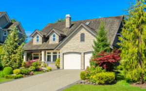 A large, modern luxury home with stone siding and a manicured lawn, representing a property eligible for a jumbo loan in California.