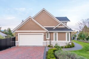 Exterior of a brown two-story suburban home with a paved driveway and two-car garage